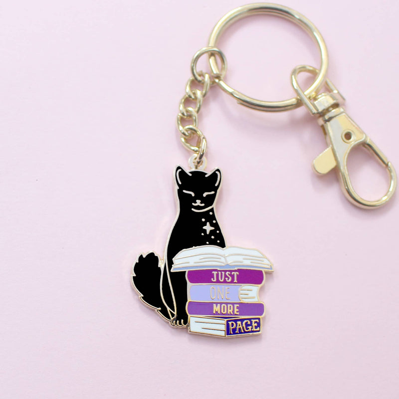 Porte-clé doré – Chat noir & livres "Juste une page de plus"