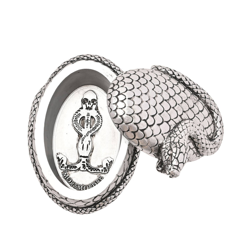 Boite argentée ovale à motif de serpent de la marque Harry Potter, vue de dessus, ouverte, avec la marque des tenebres à l'interieur