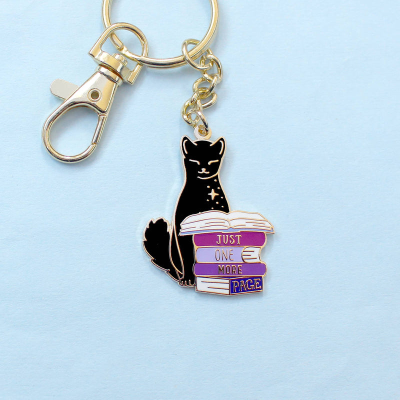 Porte-clé doré – Chat noir & livres "Juste une page de plus"